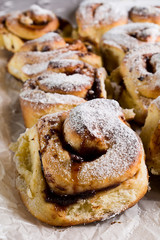 Homemade fresh baked yeast buns with plum jam. Sprinkled with icing sugar.