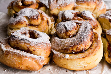 Homemade fresh baked yeast buns with plum jam. Sprinkled with icing sugar.