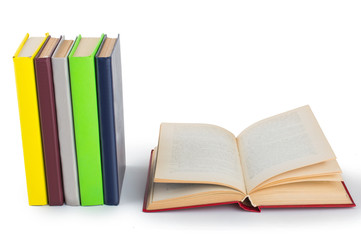 stack of multicolored books. One open. on white, isolated background.