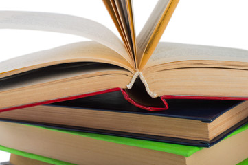 stack of multicolored books. One open. on white, isolated fone.Macro. Close up.