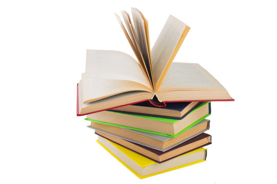 stack of multicolored books. One open. on white, isolated background.