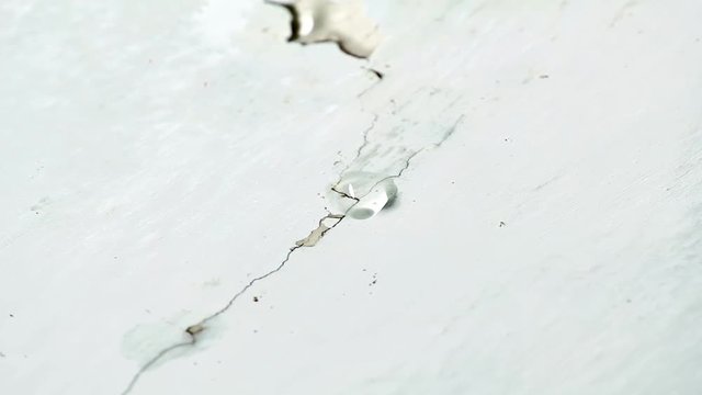 Water drips from ceiling. Faulty water supply in high-rise building. Cracked plaster on the ceiling.