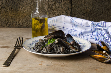 Black risotto plate with seafood.
