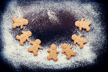 Gingerbread Men with Christmas in Dance on Dark Table