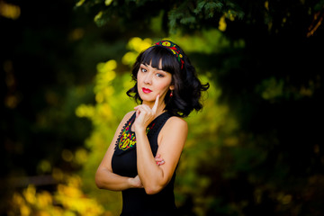 Portrait of a beautiful girl in a national dress in autumn in th