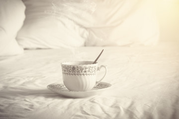 Coffee cup on sofa with pillows in morning time