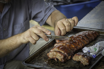 Man Cutting Barbecue Pork Ribs