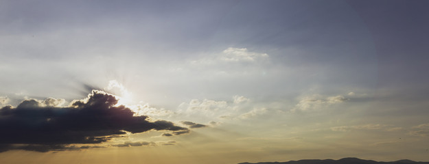 Blue and orange sunset sky with rays of sun