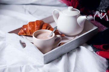 breakfast in bed with coffee and croissants