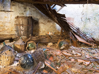 Dereliction, tumbledown abandoned property, cellar with demijohns. Bygone tradition, culture.