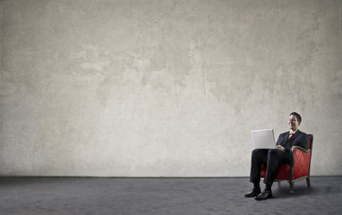 Businessman sitting in a red chair