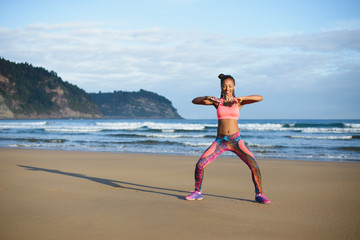 Sporty brazylijska kobieta tańczy i zabawy na plaży. Czarny szczęśliwy tancerz ciesząc się rytmem muzyki. - 122884365