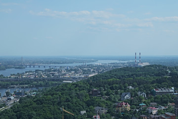 Aerial view of the city buildings, private houses, Dnieper River and bridges from Monumental statue Mother Motherland