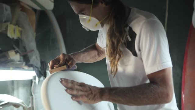 Surfboard shaping, Shaper using a foam sander to shape the side of the surfboard