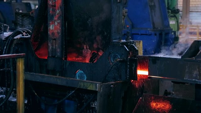 Ironworks plant. Machine bends burning hot billet