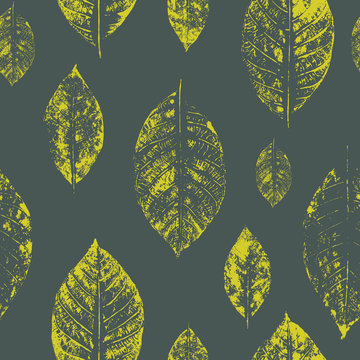 Seamless pattern made of light green leaves imprints on dark green background. Vector illustration.