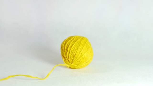 Yellow ball of wool rolls in the middle of the screen.