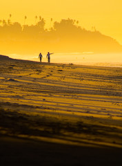Couple walking on California beach at sunset