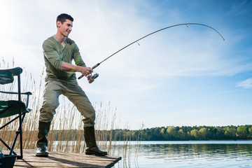 Pêcheur attrapant des poissons pêchant au bord du lac