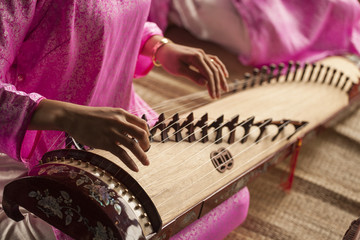 Woman play a traditional korean string instrument : the gayageum