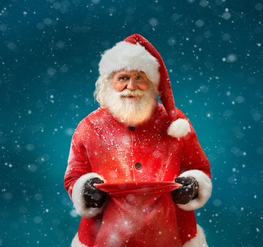 Smiling Santa Claus with open sack and looking at camera. Merry Christmas & New Year's Eve concept.