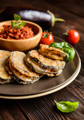 Roasted eggplant slices covered in egg, stuffed with Mozzarella, served with tomato salsa