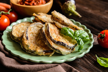 Roasted eggplant slices covered in egg, stuffed with Mozzarella, served with tomato salsa