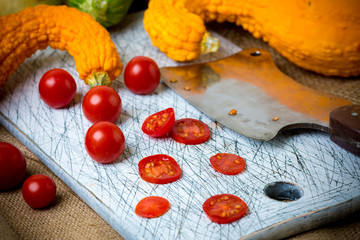 Small red cherry tomatoes spill out of on  old wooden table in r