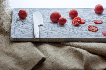 Small red cherry tomatoes spill out of on  old wooden table in r