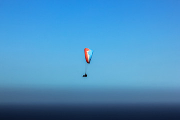 Paragliding over Table Mountain National Park in Cape Town, Western Cape, South Africa in the blue sky.