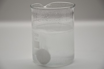 The effervescent tablet in a beaker