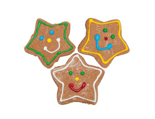 Thee Christmas gingerbread star cookies with colorful, happy icing, on white