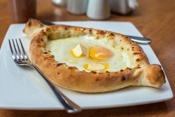 Adjarian khachapuri with eggs on the table