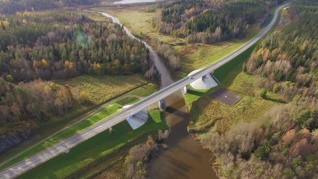 Beautiful aerial view of road bridge over the river surrounded by forest
