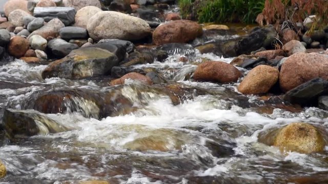 Slow motion water flowing over rocks in mountain stream in the Scottish Highlands