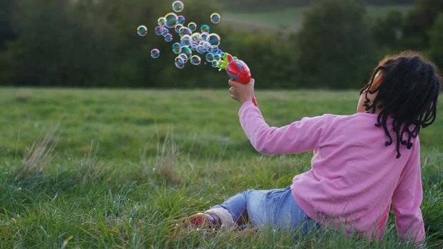 Young child playing with a bubble gun, in slow motion - version 1