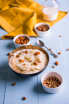 Indian sweet sutarfeni or sutar feni or firni or seviyan or laccha, shredded, flaky-rice-flour roasted in ghee, blended with melted sugar to form a cotton candy, topped with pistachio and almonds