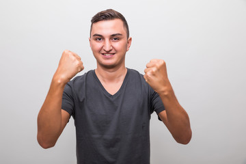 Fototapeta premium Happy excited young casual man celebrating success over grey background