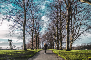 Fototapeta na wymiar Girl in the middle of trees in Edinburgh, Scotland