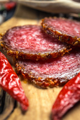 dried salami crusted in ground red pepper on dark background