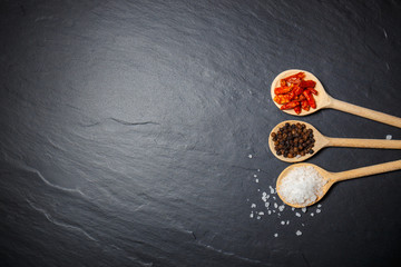 Chili with black pepper and salt on rustic stone background. Overhead view food photography.