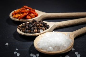 Chili with black pepper and salt on rustic stone background. Overhead view food photography.
