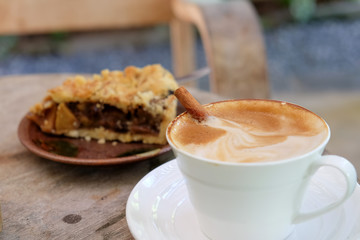 Coffee latte and apple pie on wooden table.