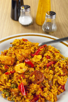 Plated chorizo chicken and king prawn paella with condiments