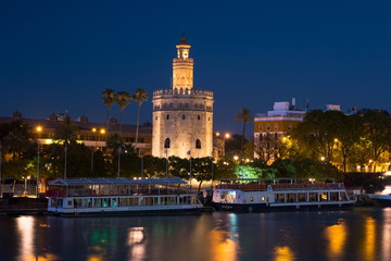 Fototapeta na wymiar View of Golden Tower, Torre del Oro, of Seville, Andalusia, Spain over river Guadalquivir at sunset. Beautiful sunset view.