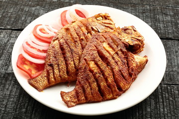Plate of tasty and spicy fried fish