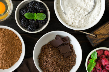 Food ingredients for cooking chocolate dessert on dark wooden ba