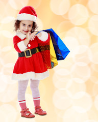Little girl in costume of Santa Claus with colorful packages