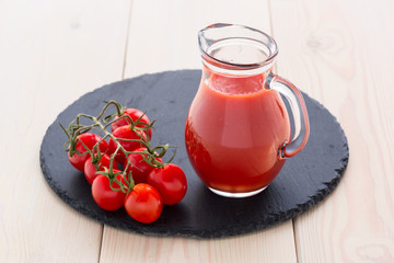 Tomato juice in a glass jar on wooden table.