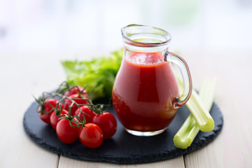 Tomato juice in a glass jar on wooden table.